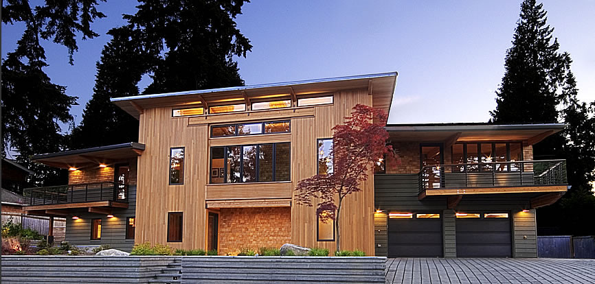 Esempio della facciata di una casa grande marrone moderna a due piani con rivestimento in legno e tetto piano