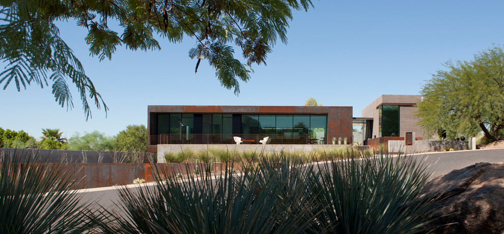 Inspiration för ett mellanstort funkis grått hus i flera nivåer, med metallfasad och platt tak