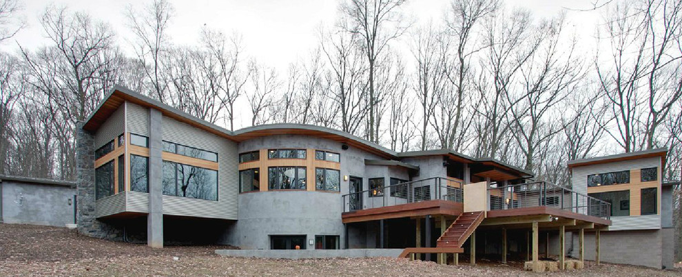 Idée de décoration pour une grande façade de maison grise design de plain-pied avec un revêtement mixte et un toit en appentis.