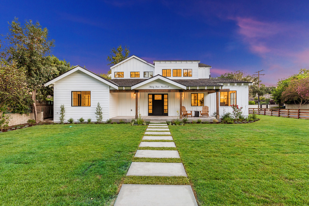 Farmhouse white two-story exterior home photo in Los Angeles with a shingle roof