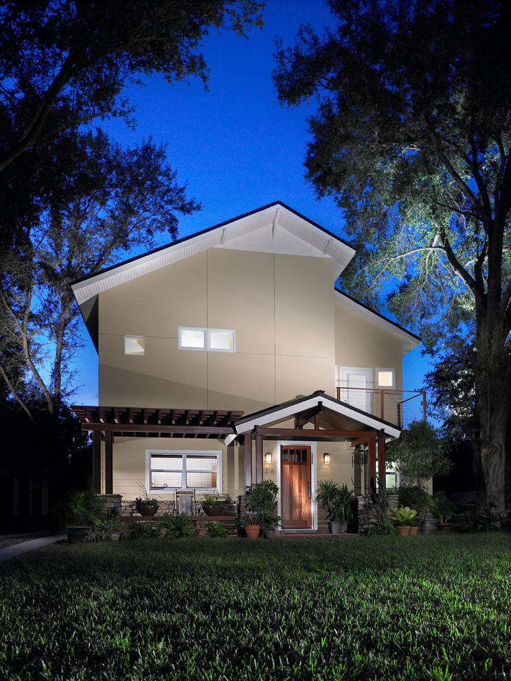 Diseño de fachada beige actual de tamaño medio de dos plantas con tejado a dos aguas