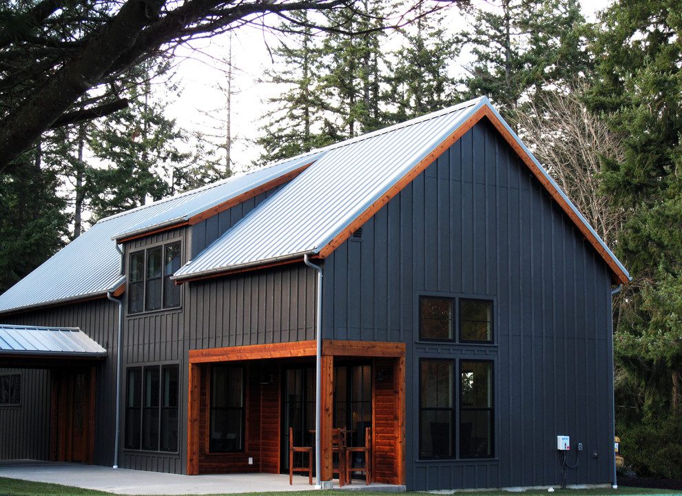 Diseño de fachada de casa negra de estilo de casa de campo de tamaño medio de dos plantas con revestimiento de madera, tejado a dos aguas y tejado de metal