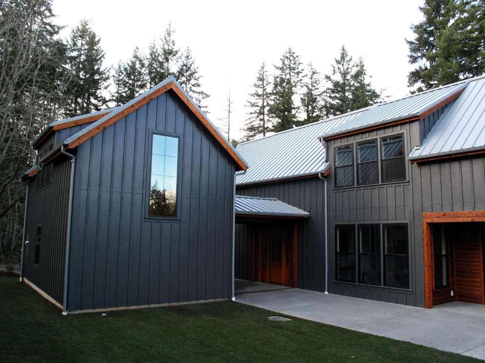 Mittelgroßes, Zweistöckiges Landhaus Haus mit schwarzer Fassadenfarbe, Satteldach und Blechdach in Seattle