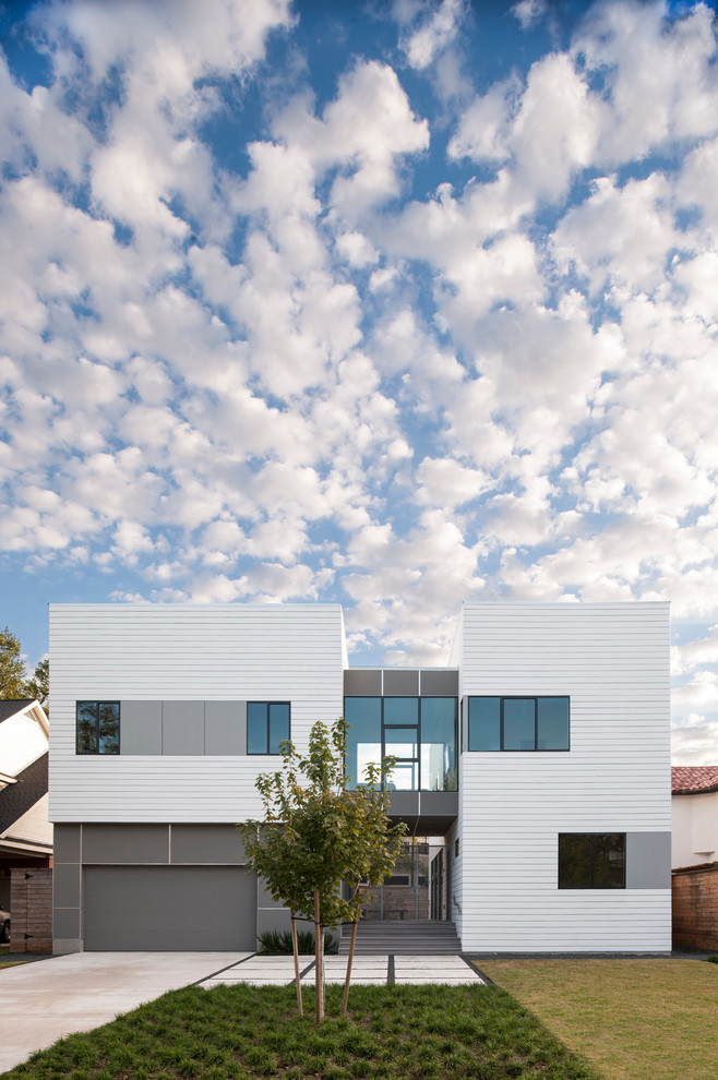 White modern two floor house exterior in Houston with wood cladding and a flat roof.