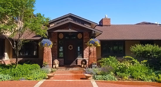 This is an example of a large and red traditional bungalow brick house exterior in Other.