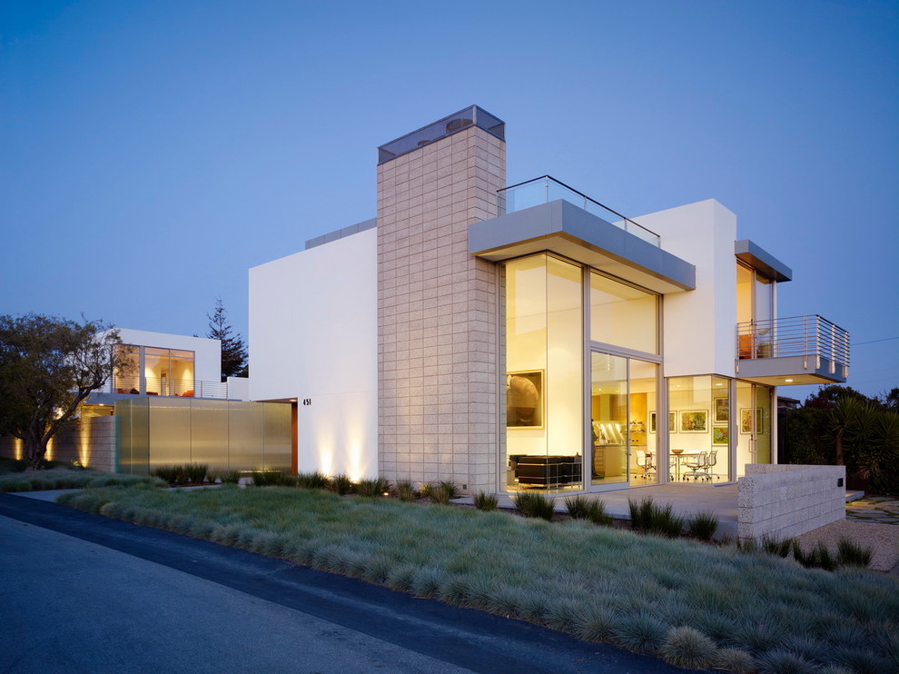 Réalisation d'une façade de maison beige minimaliste en béton à deux étages et plus avec un toit plat.