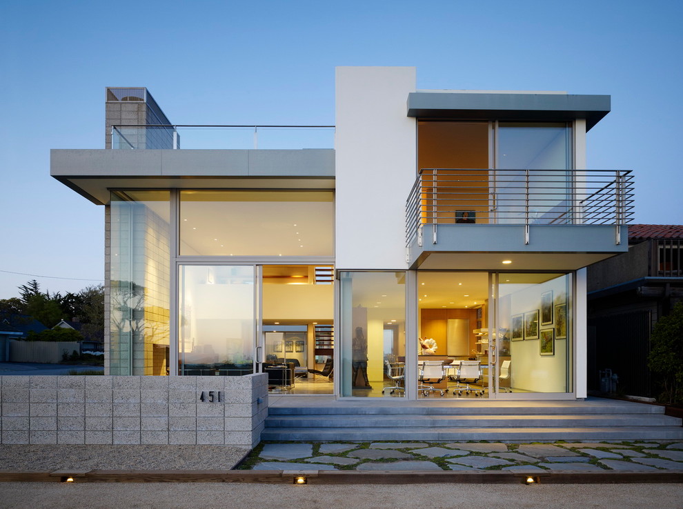Imagen de fachada de casa moderna de tres plantas con revestimientos combinados y tejado plano