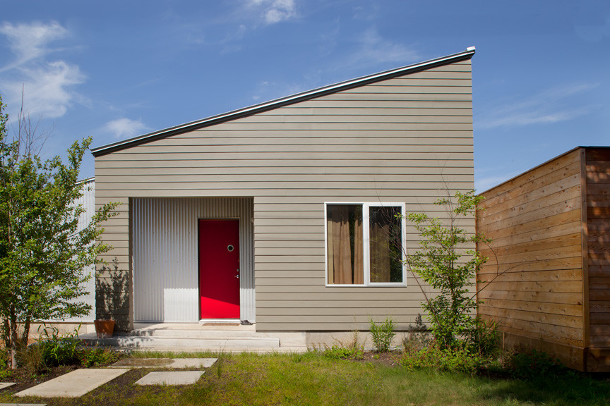 Photo of a medium sized and gey contemporary bungalow house exterior in Houston with mixed cladding.