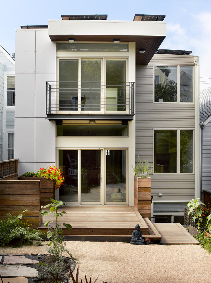 Imagen de fachada de casa gris contemporánea de tamaño medio de dos plantas con revestimientos combinados y tejado plano
