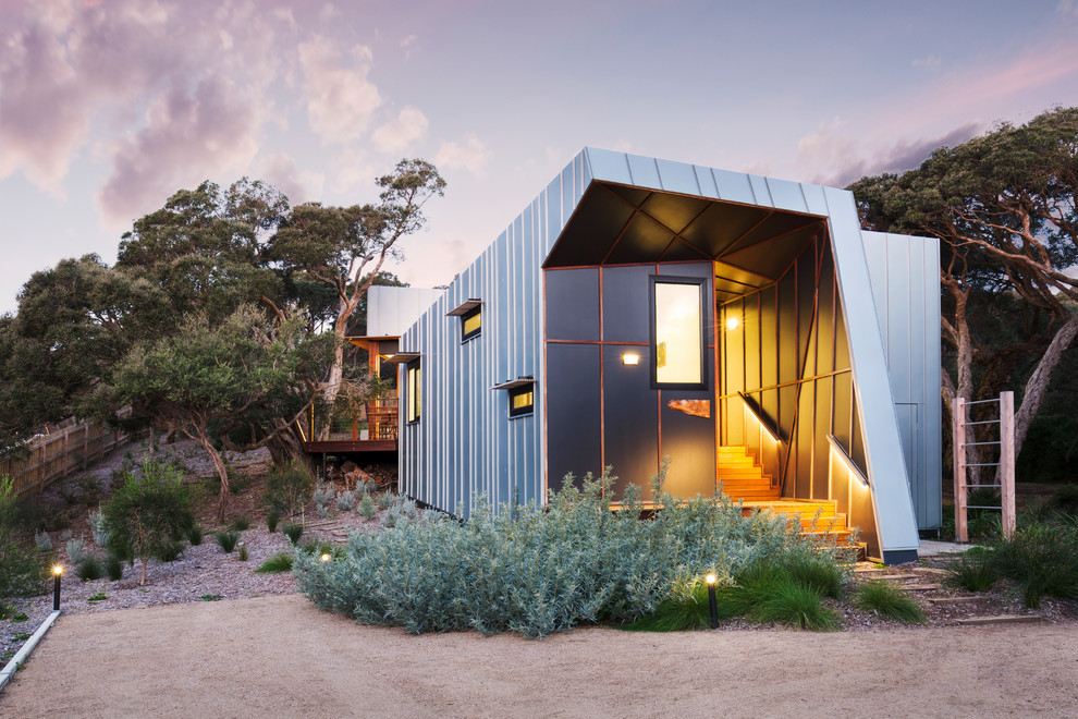 Kleines Industrial Einfamilienhaus mit Metallfassade, grauer Fassadenfarbe, Flachdach, Blechdach und grauem Dach in Melbourne
