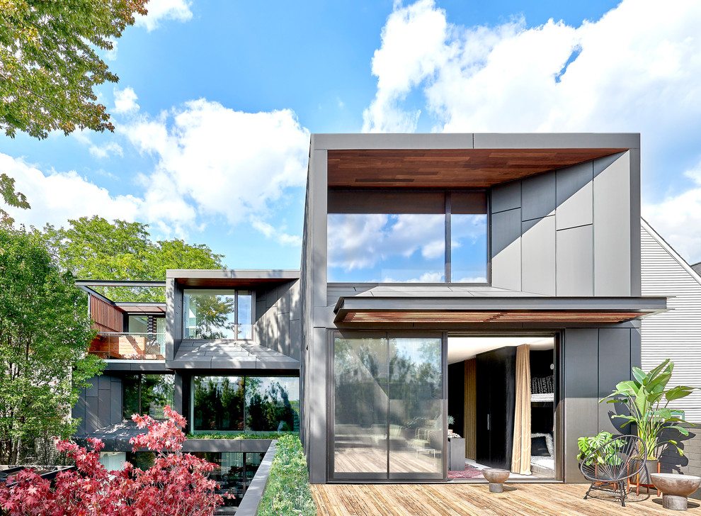 Inspiration pour une façade de maison grise design à un étage avec un toit plat.