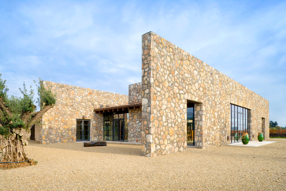 Свежая идея для дизайна: одноэтажный, бежевый дом в средиземноморском стиле с облицовкой из камня и плоской крышей - отличное фото интерьера