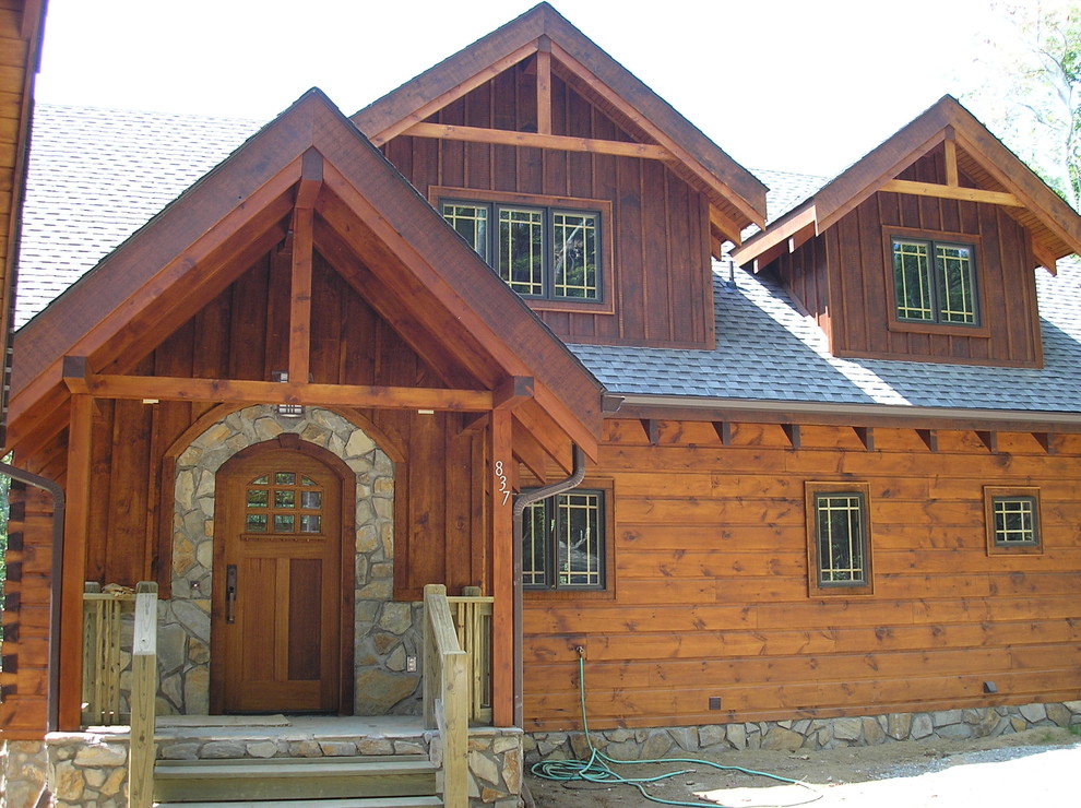 Idée de décoration pour une façade de maison marron chalet en bois de taille moyenne et à un étage.