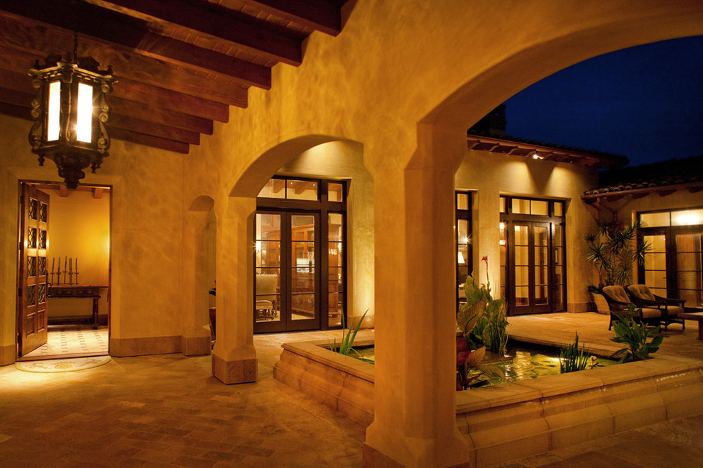 Example of a large tuscan beige two-story stucco exterior home design in San Diego