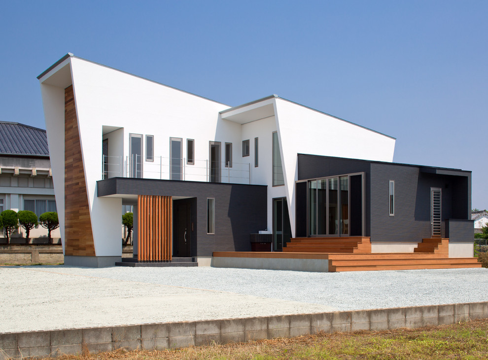 Cette image montre une façade de maison blanche design à un étage avec un revêtement mixte et un toit plat.