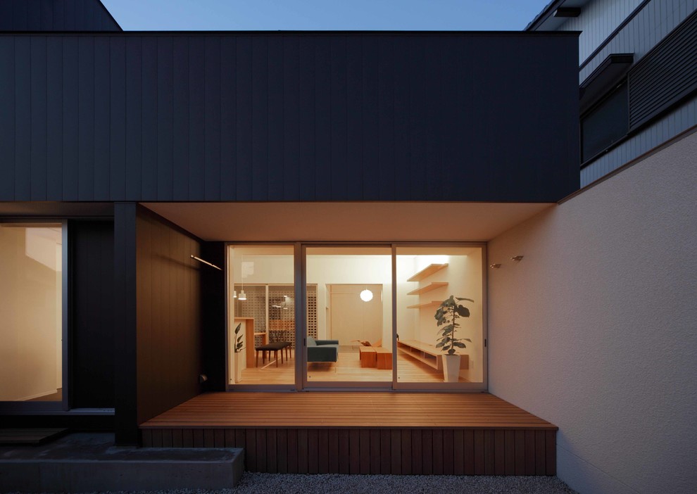 Идея дизайна: маленький, двухэтажный, черный частный загородный дом с облицовкой из металла, односкатной крышей и металлической крышей для на участке и в саду