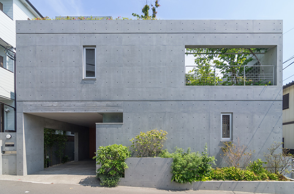 Esempio della facciata di una casa grigia industriale a due piani di medie dimensioni con rivestimento in cemento e tetto piano