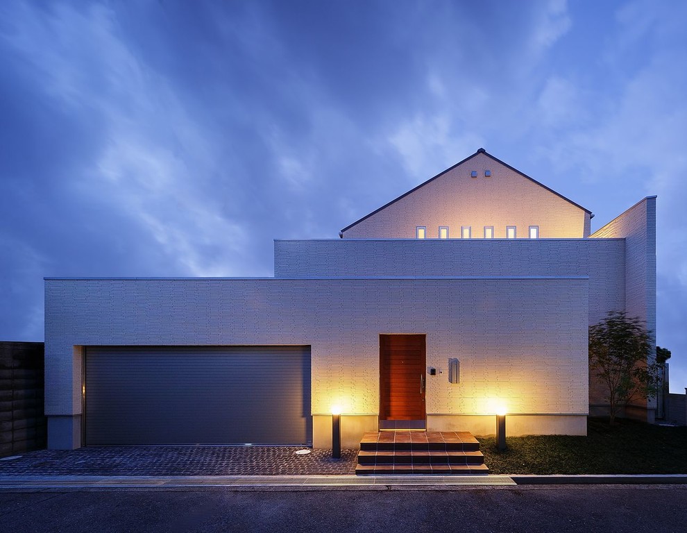 Diseño de fachada de casa blanca contemporánea grande de dos plantas con tejado a dos aguas y tejado de metal