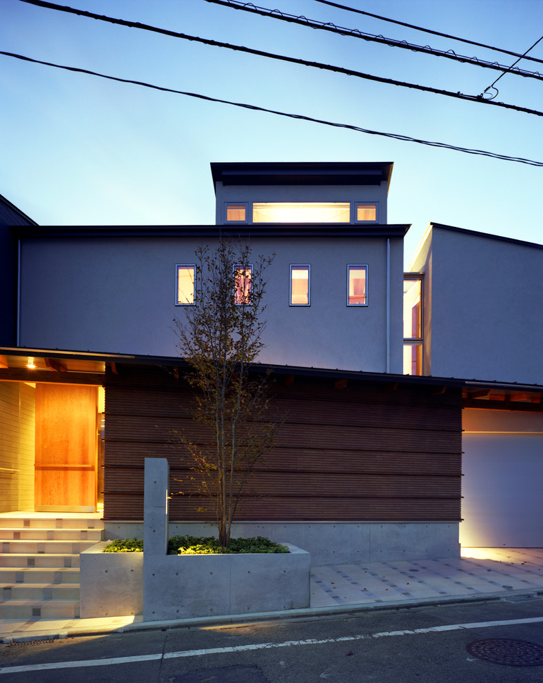 Large and brown world-inspired two floor brick detached house in Tokyo with a lean-to roof and a metal roof.