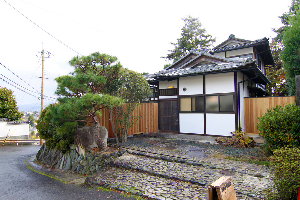 Источник вдохновения для домашнего уюта: двухэтажный, белый дом в японском стиле в восточном стиле с комбинированной облицовкой и двускатной крышей