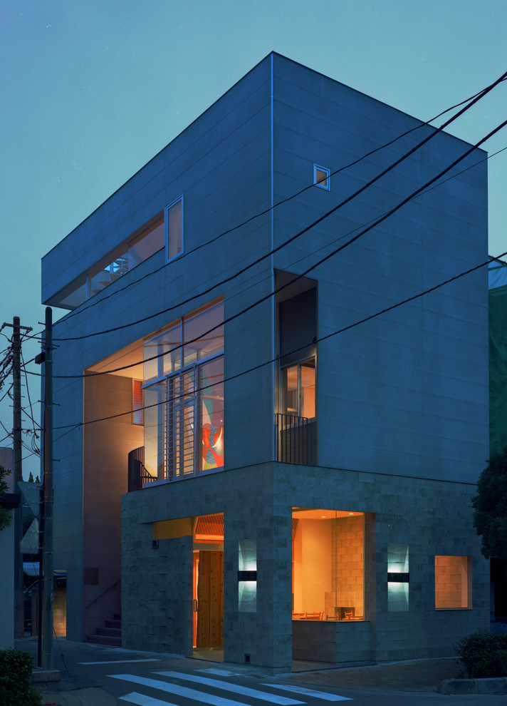Mittelgroße, Dreistöckige Moderne Doppelhaushälfte mit Faserzement-Fassade, grauer Fassadenfarbe und Flachdach in Tokio
