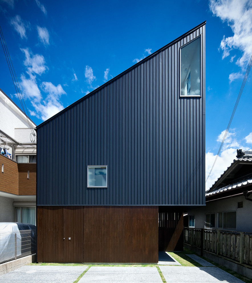 Aménagement d'une façade de maison noire contemporaine avec un toit en appentis.