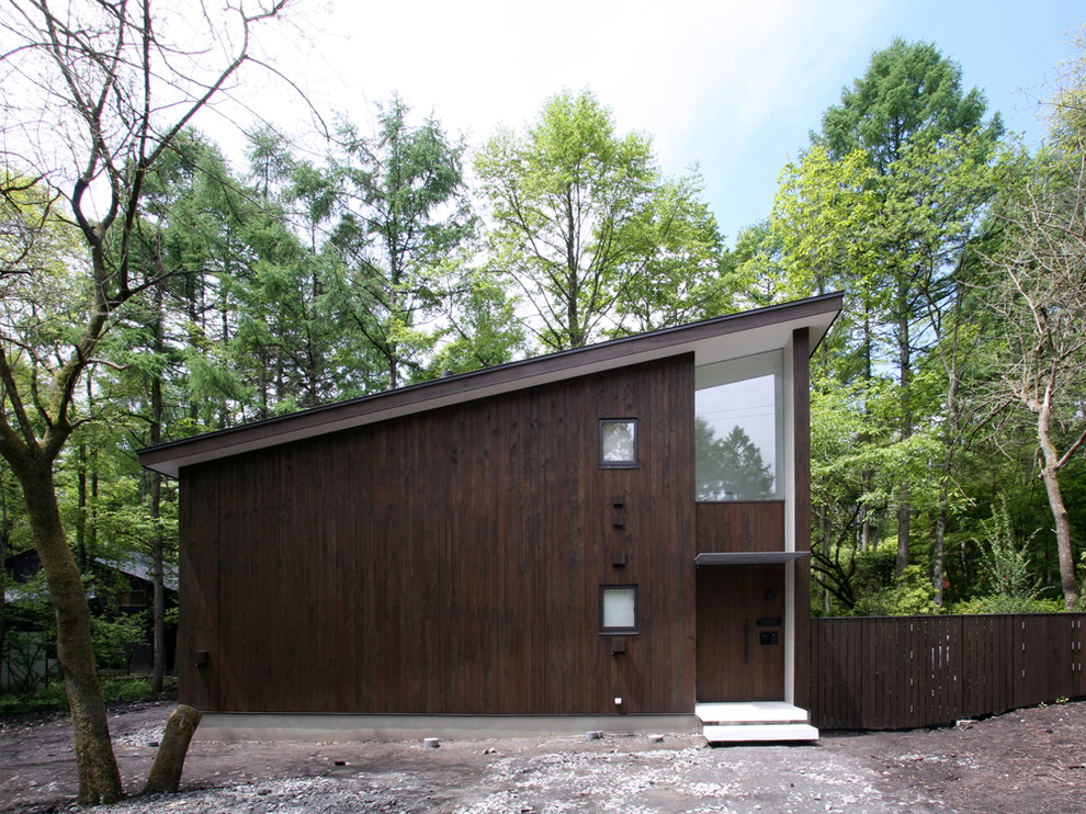 Exemple d'une façade de maison marron tendance en bois à un étage avec un toit en appentis.