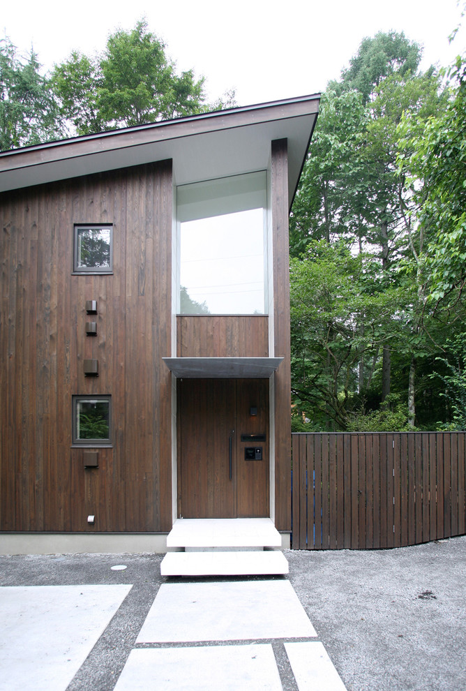 Пример оригинального дизайна: двухэтажный, деревянный, коричневый дом в современном стиле с односкатной крышей