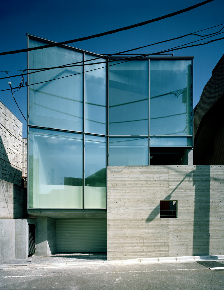 Modern glass house exterior in Tokyo with a flat roof.