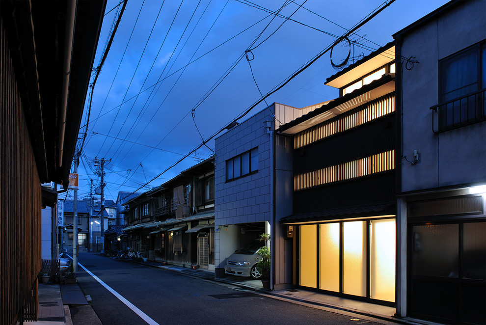 Mid-sized traditional brown three-story metal and board and batten exterior home idea in Kyoto with a tile roof and a gray roof