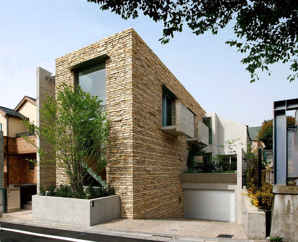 Exemple d'une façade de maison beige tendance en pierre avec un toit plat.