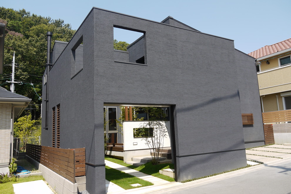 Cette photo montre une façade de maison grise moderne en stuc de taille moyenne et à un étage avec un toit à deux pans et un toit en métal.