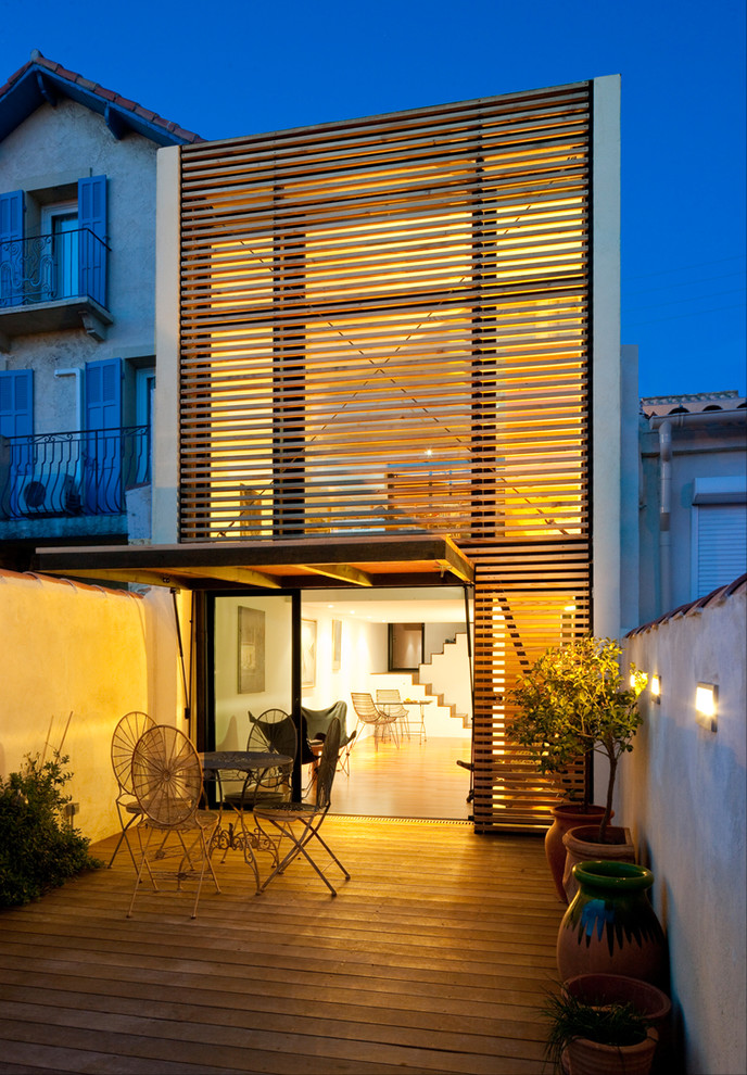 Diseño de fachada blanca contemporánea pequeña de dos plantas con revestimiento de madera y tejado plano