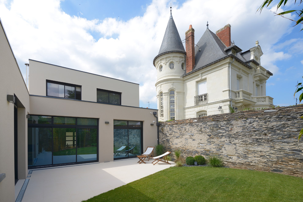 Ispirazione per la facciata di una casa beige contemporanea a due piani di medie dimensioni con tetto piano