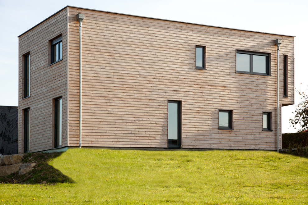 Réalisation d'une façade de maison marron minimaliste en bois de taille moyenne et à un étage avec un toit plat.