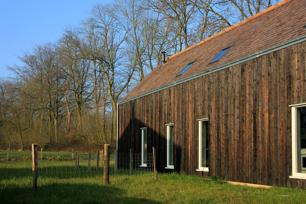 Foto de fachada negra contemporánea pequeña de tres plantas con revestimiento de madera y tejado a dos aguas