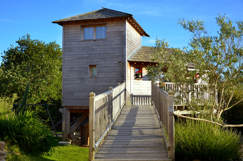 Foto della facciata di una casa country a due piani di medie dimensioni con rivestimento in legno e tetto a padiglione