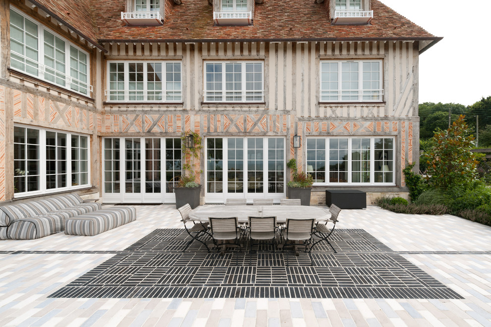 Idée de décoration pour une grande façade de maison champêtre à deux étages et plus avec un toit à quatre pans.