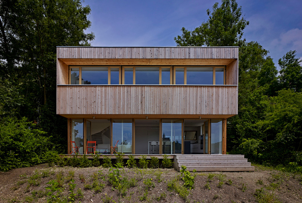 На фото: двухэтажный, деревянный, коричневый вилла среднего размера в стиле модернизм с плоской крышей с