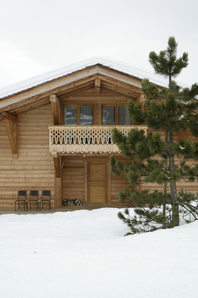 На фото: двухэтажный, деревянный, коричневый дом среднего размера в стиле рустика с двускатной крышей с
