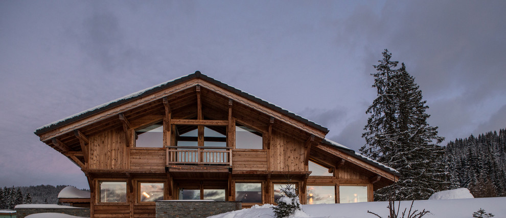 На фото: большой, трехэтажный, деревянный, бежевый дом в стиле рустика с двускатной крышей с