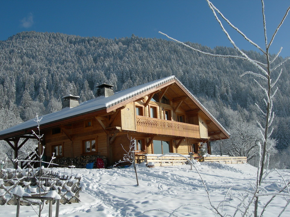 Cette photo montre une grande façade de maison marron montagne en bois à deux étages et plus avec un toit à deux pans.