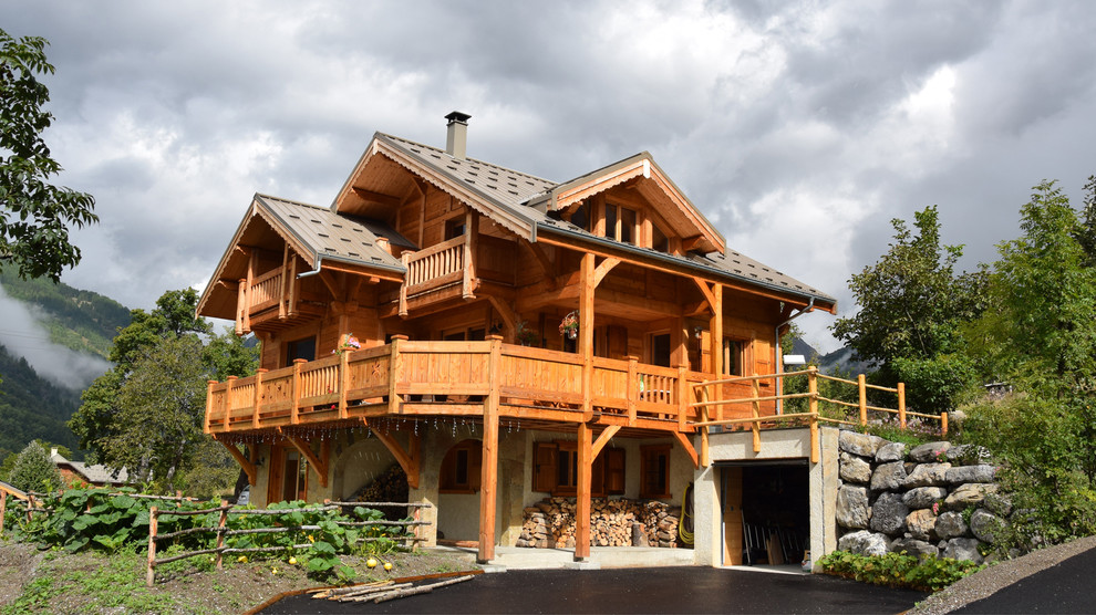 Aménagement d'une grande façade de maison montagne en bois à deux étages et plus avec un toit à deux pans.