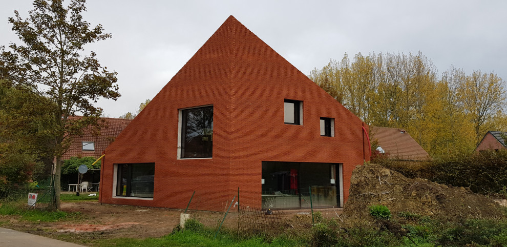На фото: большой, двухэтажный, кирпичный, красный частный загородный дом в современном стиле с двускатной крышей и черепичной крышей