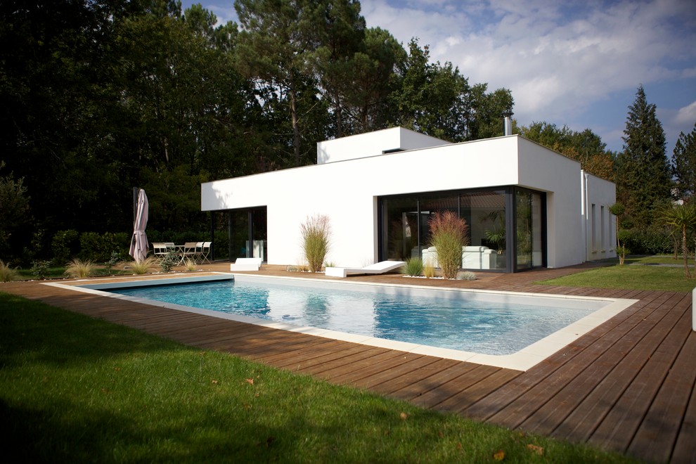 Свежая идея для дизайна: одноэтажный, белый дом среднего размера в стиле модернизм с плоской крышей - отличное фото интерьера