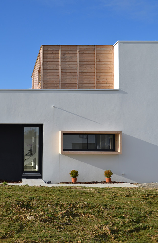 Zweistöckiges, Mittelgroßes Modernes Haus mit weißer Fassadenfarbe und Flachdach in Nantes