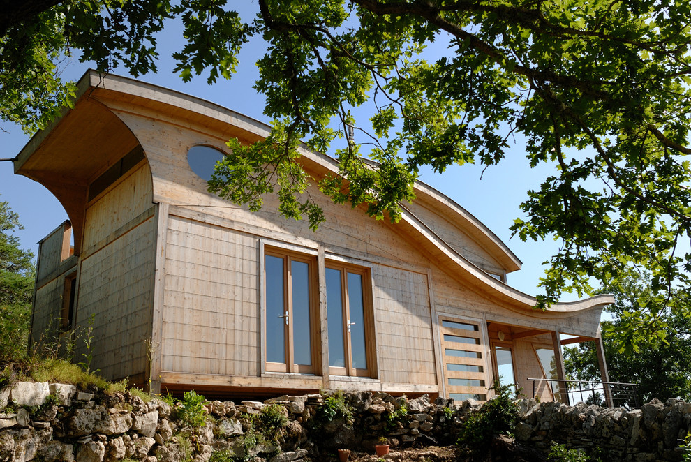 Inspiration pour une façade de maison marron design en bois de taille moyenne et à un étage avec un toit en appentis.