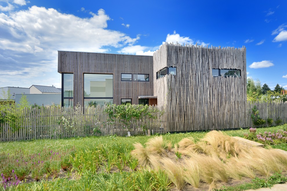 Mittelgroße Moderne Holzfassade Haus mit brauner Fassadenfarbe und Flachdach in Rennes