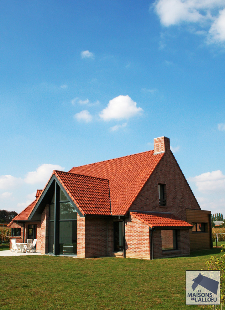 Modelo de fachada roja actual grande de dos plantas con revestimiento de ladrillo y tejado a la holandesa