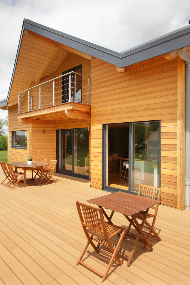 Imagen de fachada marrón campestre de tamaño medio de dos plantas con revestimiento de madera y tejado a dos aguas